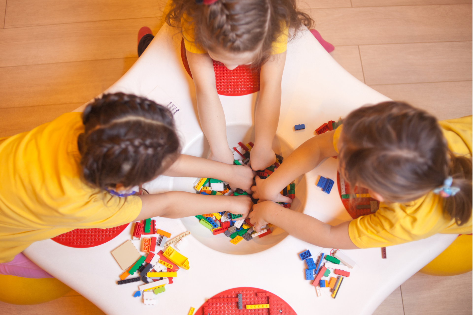 Infants jugant a una taula amb peces de construcció.