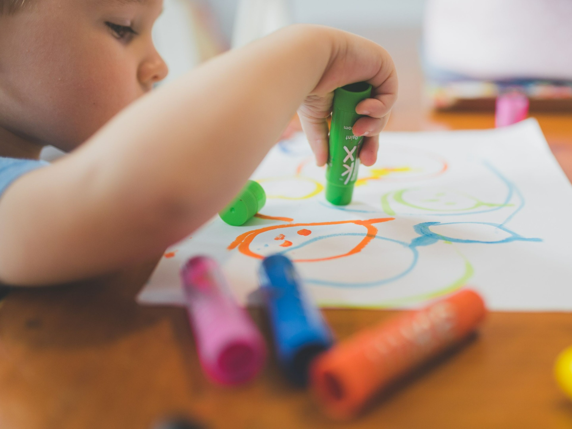 Un infant dibuixa amb retoladors de colors.