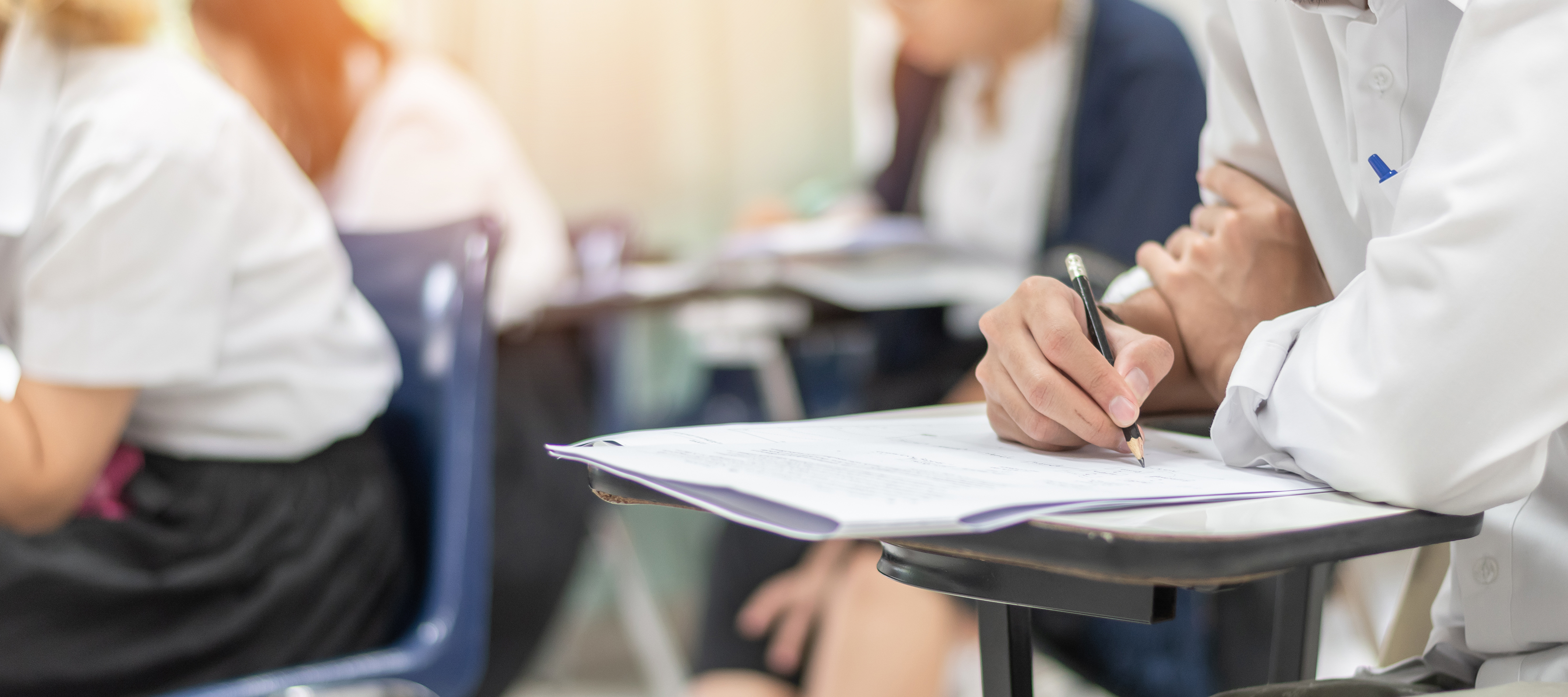 Un grup de persones respon un examen escrit.