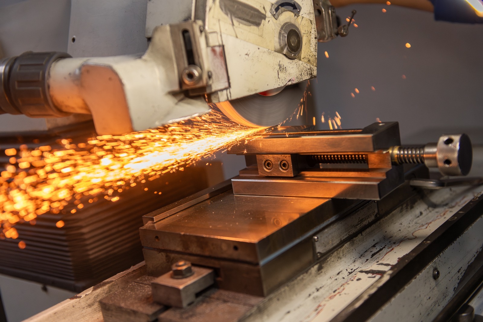 Una màquina talla una peça metàl·lica i genera espurnes.