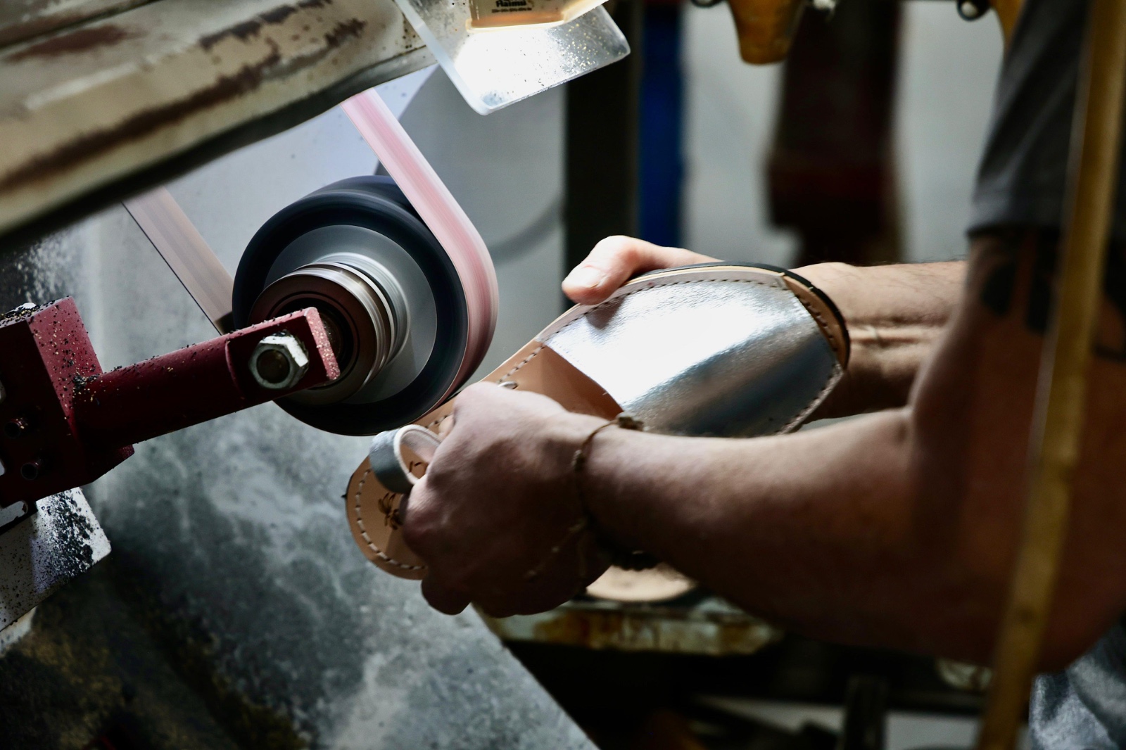 Una màquina poleix la sola d'una avarca menorquina.