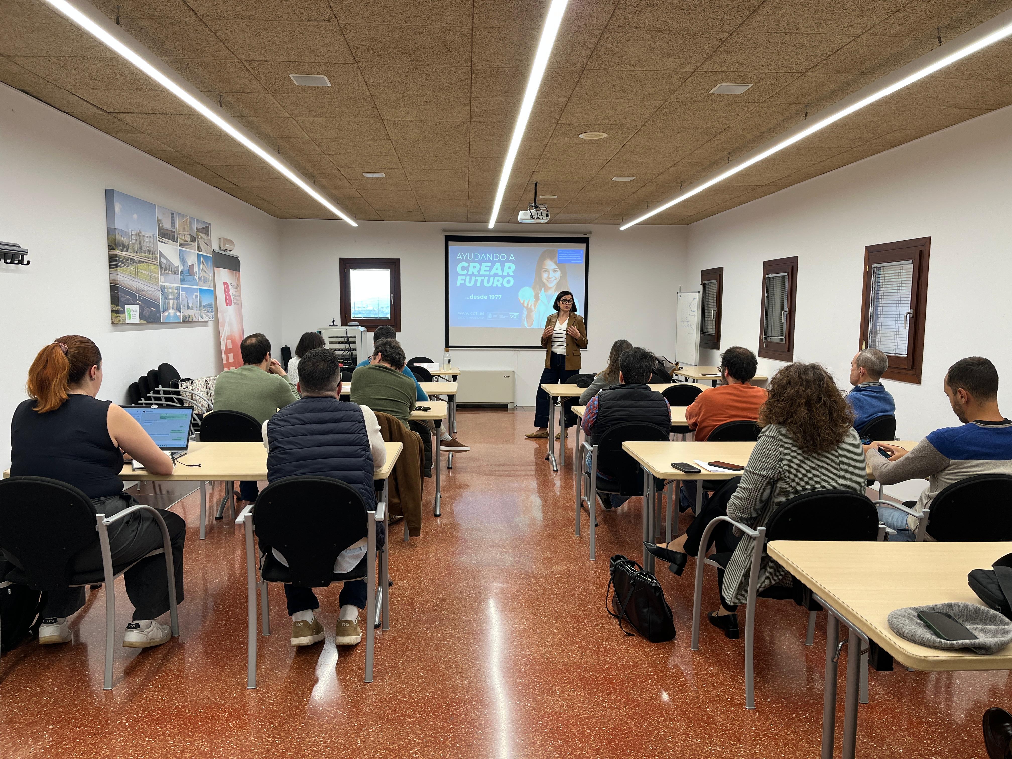 Moment de la jornada informativa, on una ponent parla davant persones assegudes. 