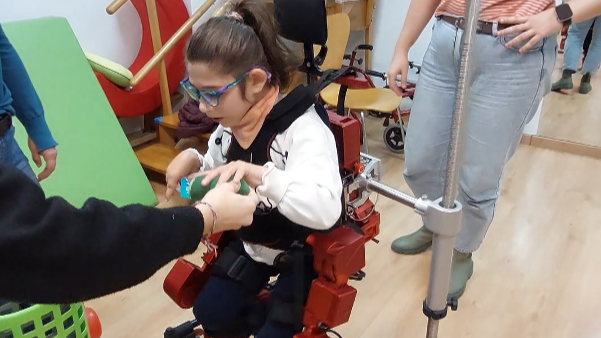 Una nina utilitza l’exoesquelet pediàtric.