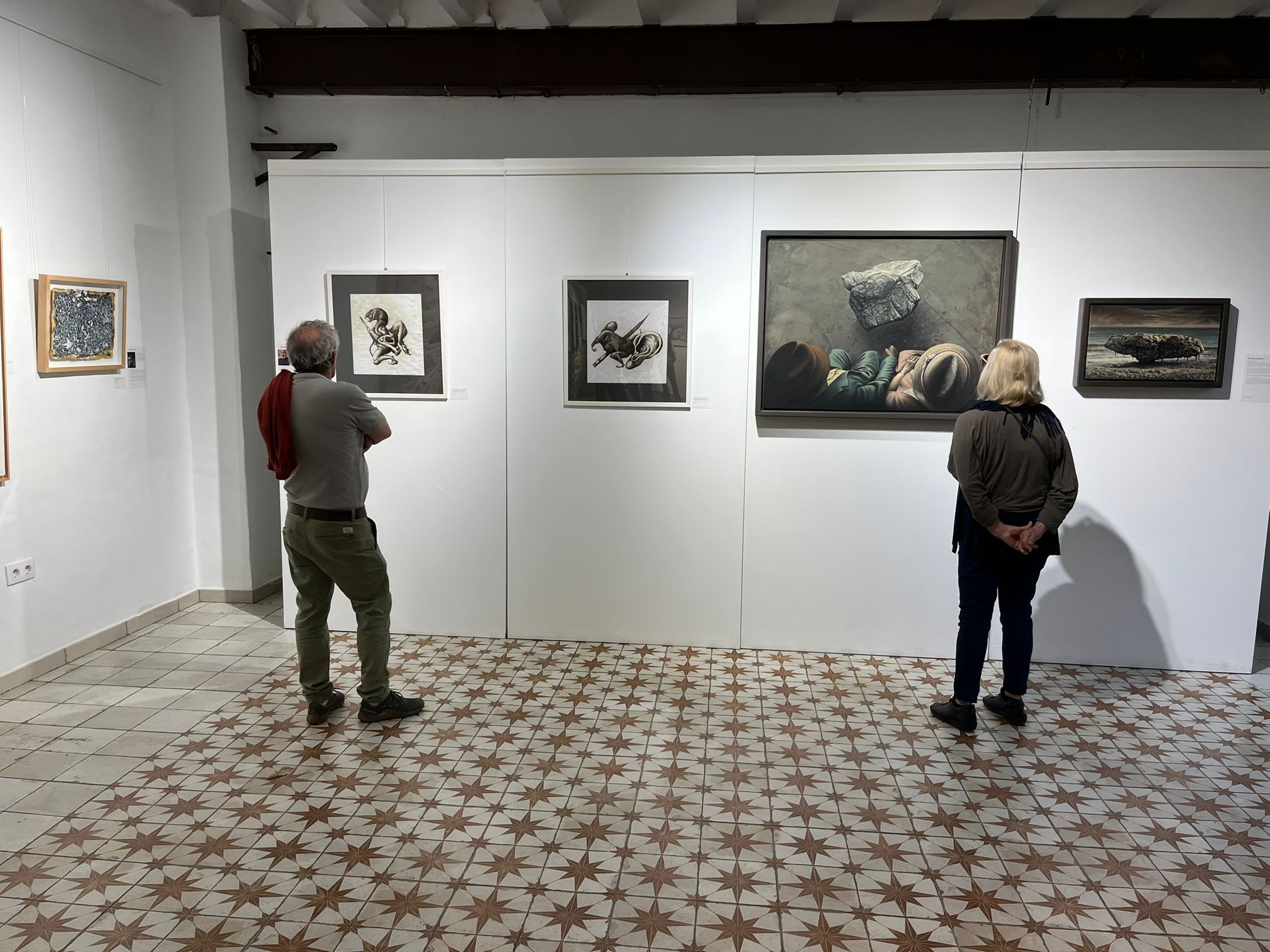 Dues persones observen obres de l'exposició «Els somnis dels baleàrics».