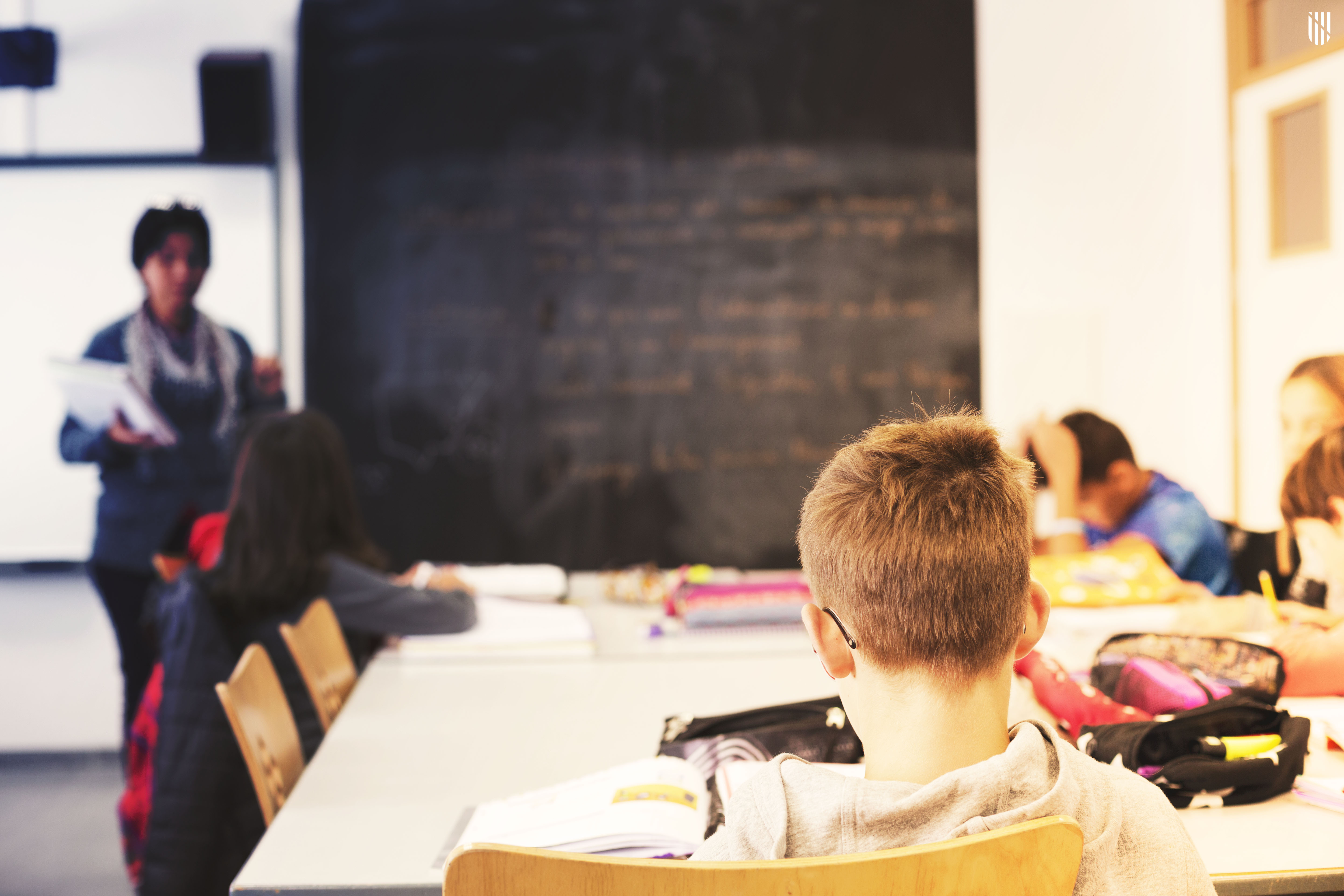 Una aula d'educació primària amb una mestra i alumnes. 