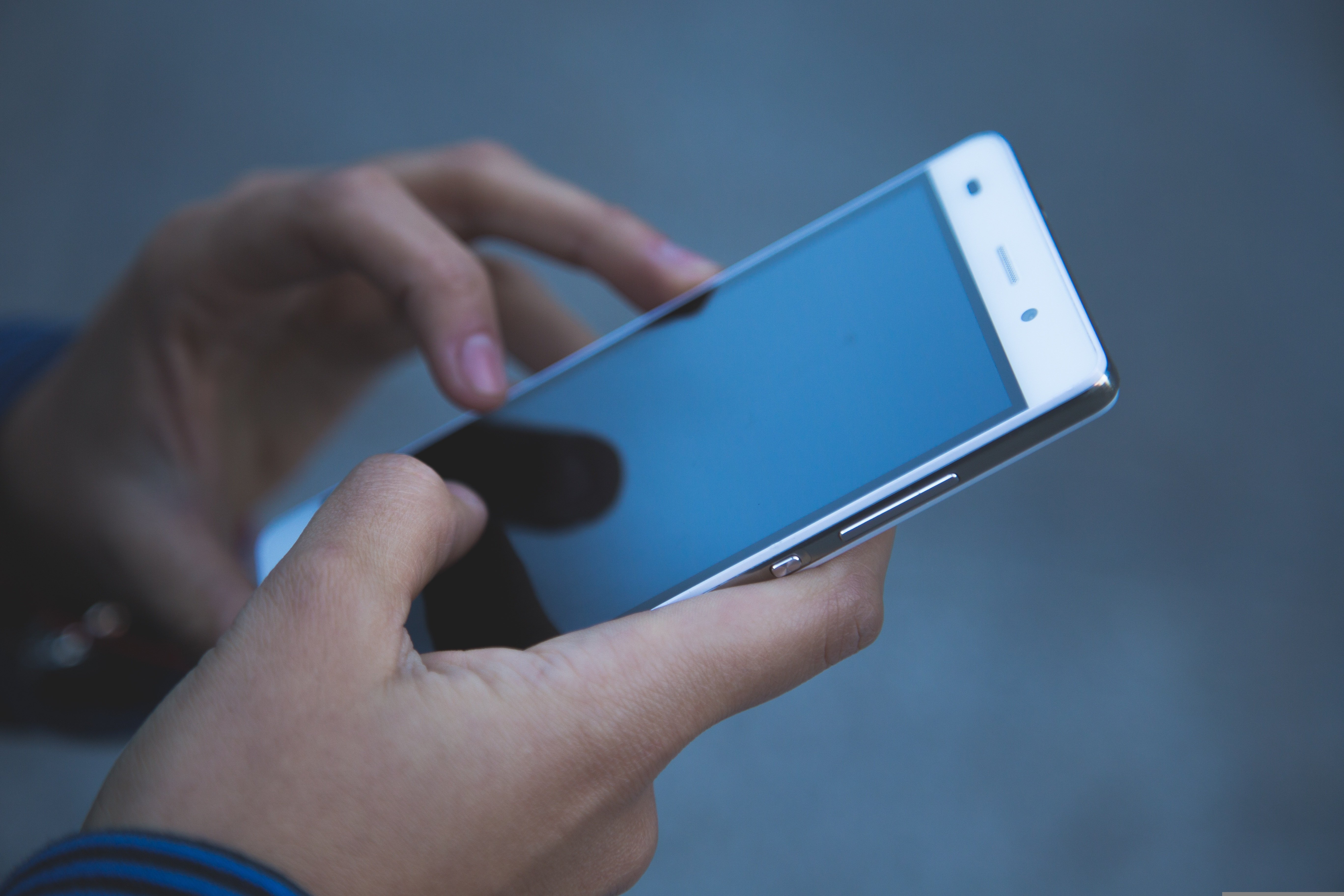 Unes mans subjecten un telèfon mòbil intel·ligent. 