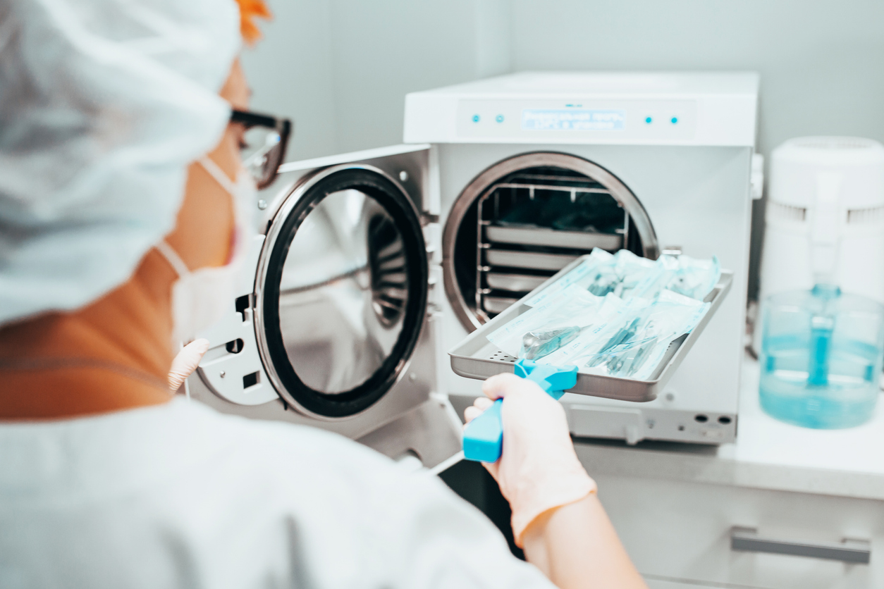Una tècnica sanitària esterilitza una safata amb instrumental mèdic